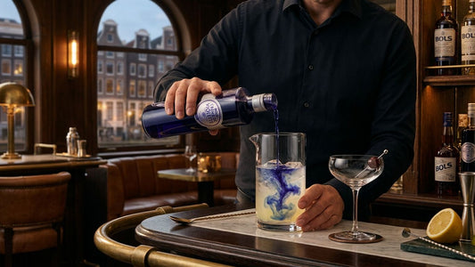 Bartender pouring Bols liqueur into a glass while preparing an aviation cocktail with gin and botanical ingredients