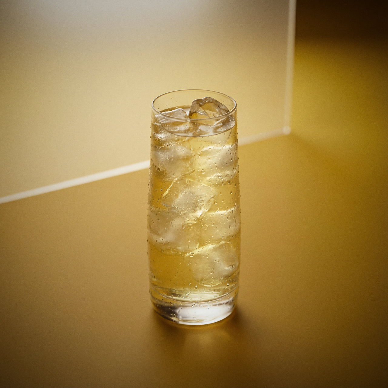 banana easy mix cocktail with banana liqueur in highball glass on textured surface