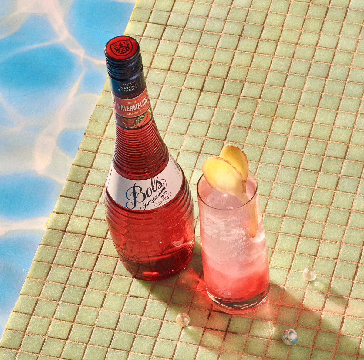 watermelon cocktail in highball glass by the pool side in summer made with bols watermelon liqueur