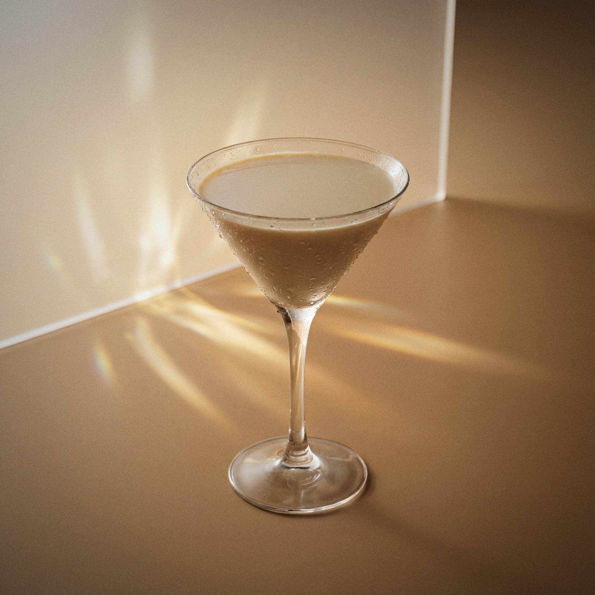 cappuccino martini cocktail with brown cream liqueur and vodka in a martini glass on a textured surface