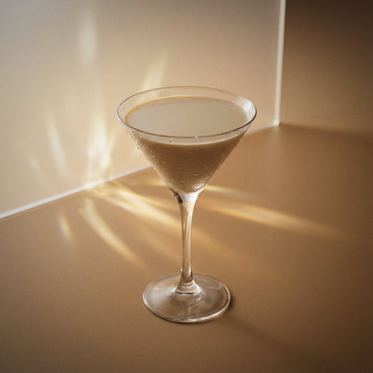 cappuccino martini cocktail with brown cream liqueur and vodka in a martini glass on a textured surface