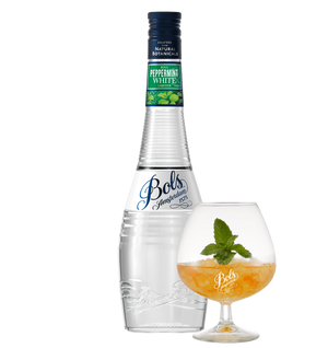 A bottle of Bols Peppermint White liqueur next to a filled glass with a peppermint cocktail, both with a hint of green mint leaves.