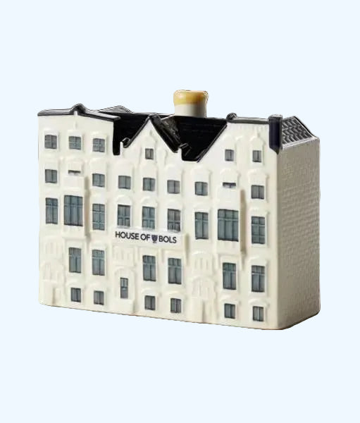 A miniature model of a traditional Dutch 'Delft blue' house, predominantly white and blue in color, with 'HOUSE OF BOLS' branding on the front.